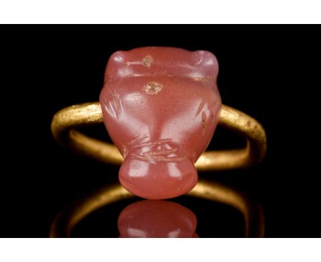 Ca. 500-400 BC. A striking carved carnelian bull's head mounted on a high karat yellow gold swivel (not full rotation) ring. 