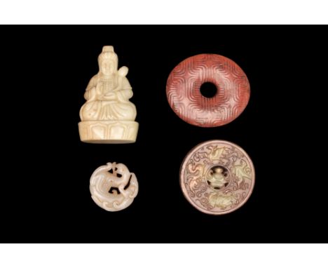 . A group of hardstone artifacts including a seated Buddha, two bi discs, and a chilong carving. Bi is a flat, circular disc 
