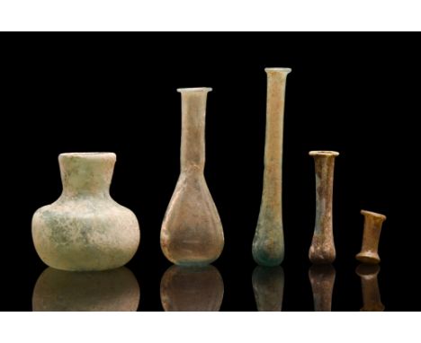 Ca. 100-300 AD. A fine group of five distinctly shaped glass flasks used to store perfumed oil, or unguentum. The shapes in t