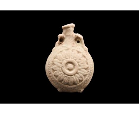 Ca. 660-525 BC. An interesting faience New Year's flask of a lentoid body with twin arched handles flanking the trumpet-shape