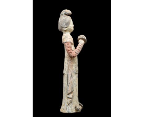 Ca. 618-907 AD. A mold-formed pottery tomb attendant figure in the form of a female musician playing cymbals. She is wearing 