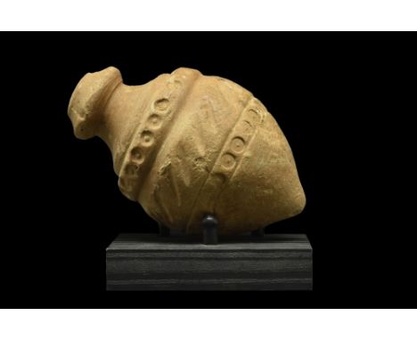 Ca. 900-1200 AD. A "Greek Fire" hand grenade comprising a cream ceramic vessel with a spheroconical body, and a short, squat 