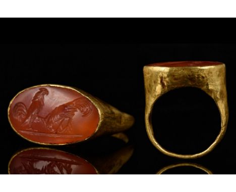 Ca. 100-200 AD. A substantial gold ring with hollow hoop widening to the shoulder; oval bezel carnelian intaglio engraved wit