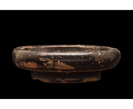 Ca. 350 BC. An attractive salt cellar / small bowl covered in a glossy glaze. The vessel features a broad basin with an incur