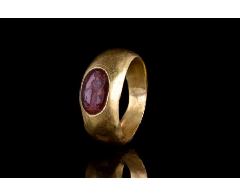 Ca. 200-300 AD. A beautiful gold finger of a round hoop with smooth sides tapering to the back. Oval bezel set with a carneli