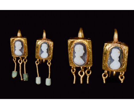 Ca. 100-200 AD. A remarkable pair of gold earrings, each comprised of a loop and a rectangular-shaped box bezel set with a fi