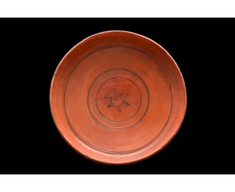 Ca. 300-400 AD. A finely made wheel-thrown redware pottery dish, with a squat form that rests atop a low ring base. The dish 
