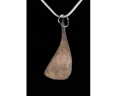 Northern Europe, Ca. 700–900 AD. A beautiful silver pendant with an integral loop shaped like a bearded Viking axe head. Good