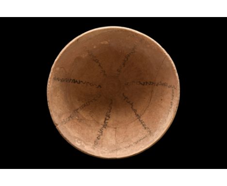 Ca. 600-800 AD. A rounded bottomed terracotta bowl with written incantations in Aramaic, radiating around the basin. The use 