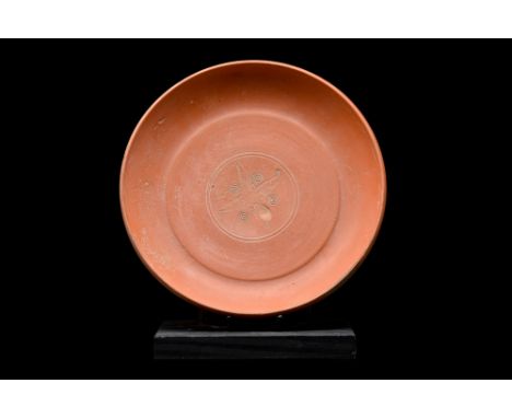 Ca. 300-400 AD. An ancient Roman wheel-thrown redware pottery dish of a squat form that rests atop a flat base. The vessel fe