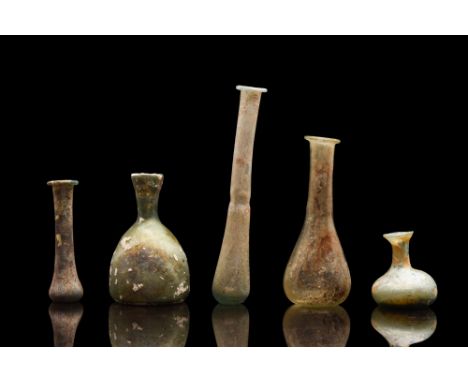 Ca. 100-300 AD. A fine collection of five Roman glass flasks to store perfumed oil, or unguentum. These glass vessels were an