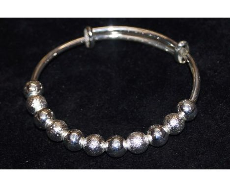 White metal extendable fashion bangle set with 11 frosted and clear "beads"
