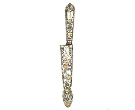 An .800 silver Argentinian Goucho knife, 14cm blade with maker’s mark, characteristic hilt embossed with foliage and flowers,