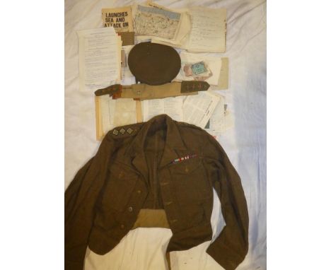 A 1940 khaki battle dress blouse with Captain's rank insignia and medal ribbons together with 1945 dated officer's peaked cap