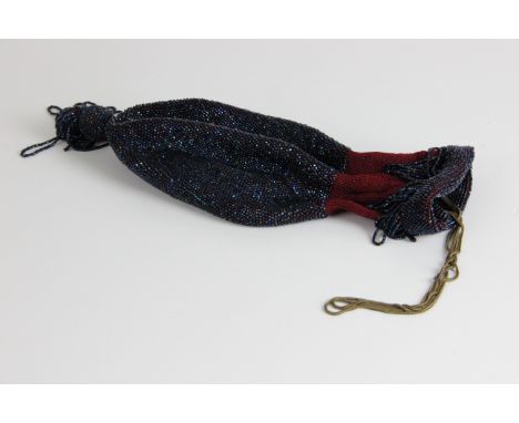A glass beaded draw string bag, of money purse form with large ball tassel drop, the whole beaded in iridescent 'scarab' bead