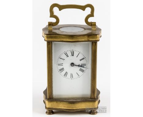 A late 19th/ early 20thC brass carriage clock, the white enamel dial with black painted roman numerals in a serpentine brass 