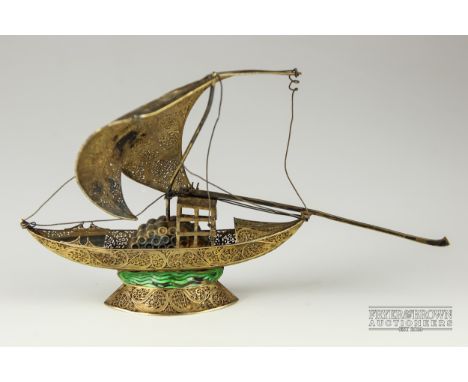 An antique silver gilt filigree and enamel model of a boat, c1880, the very fine scrolled filigree boat with port sherry cask