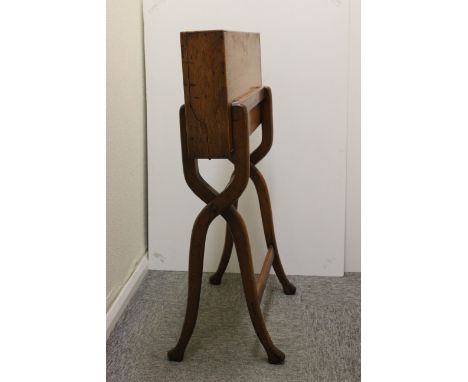 A folding light oak campaign desk, sabre legs, lined with red leather, desk blotter, original ink well, paper holder and stat