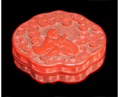 A Chinese cinnabar lacquer box and cover, of mirror form, decorated with a seated male figure with scroll amid stylised cloud