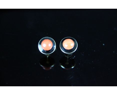 A pair of gold, black enamel and coral earrings, of disc form, the black enamel set to the centre with a single bouton shaped