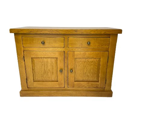 Solid light oak sideboard, rectangular top fitted with two drawers and two cupboards with panelled fronts, on plinth baseDime