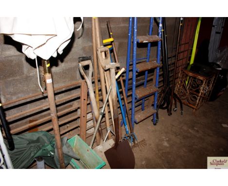 A collection of long handled gardening tools to include rakes and spades
