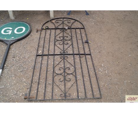 A wrought iron arch top garden gate