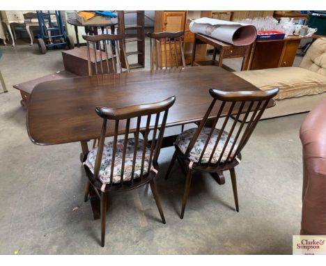 An Ercol dining table with a set of four stick back Ercol chairs