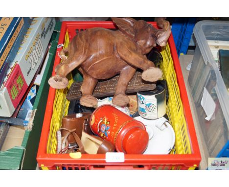 A box of various items to include carved wooden elephant, a cribbage board, camera and leather case, enamelled chamber sticks