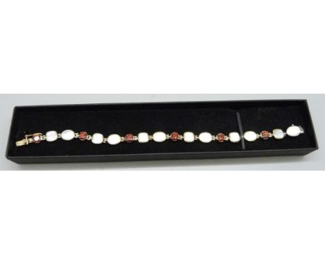 A silver gilt pearl and red stone bracelet 