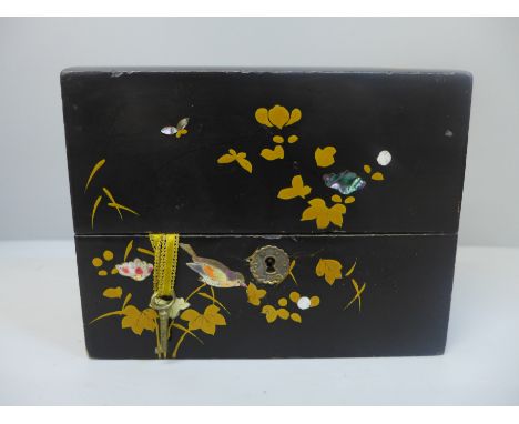 A Victorian black lacquer perfume container with mother of pearl and gilt bird and flower decoration with three glass bottles