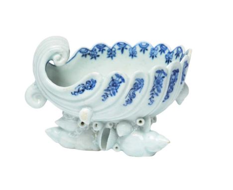 A Bow blue and white shell salt, c.1755, moulded as a deep fluted shell painted with stylised blue flower sprays, the interio