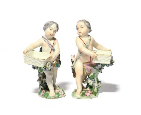 A pair of Chelsea sweetmeat figures, c.1760, each modelled as a putto wearing a bow and a quiver of arrows, each holding a sq
