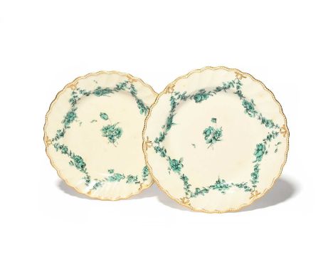 A pair of Chelsea-Derby plates, c.1770, painted in green and black with a central flower spray within garlands suspended from