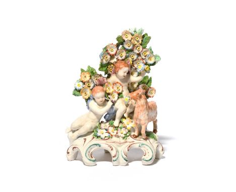 A Plymouth figure group, c.1770, modelled with two putti and a goat before flowering bocage, raised on a tall scrolled base w