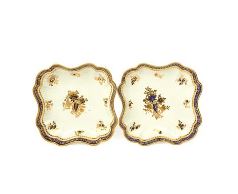 A pair of Caughley dessert dishes, c.1790, the shaped square forms decorated in gilt and blue with a central flower spray and