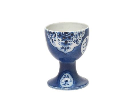 A rare Bow blue and white egg cup, c.1762, painted with shaped panels of flowers and leaves and small floret roundels, reserv