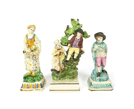 Three Staffordshire figure groups, c.1800-20, one of haymakers seated beneath leafy bocage on a tall base, a Pratt ware figur