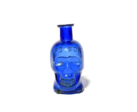 A large Death's Head poison bottle, late 19th century, the glass a rich cobalt blue, formed as a skull with 'Poison' embossed