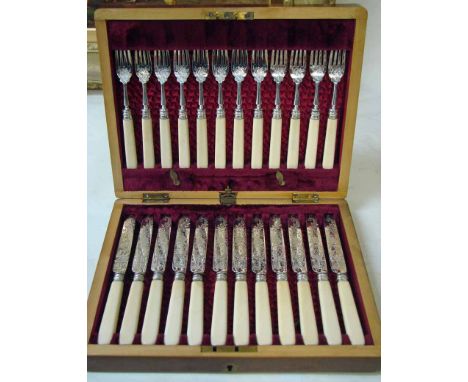 A Victorian walnut canteen of twelve sets of fish eaters, foliate and scroll engraved silver blades and tines, ivory handles,