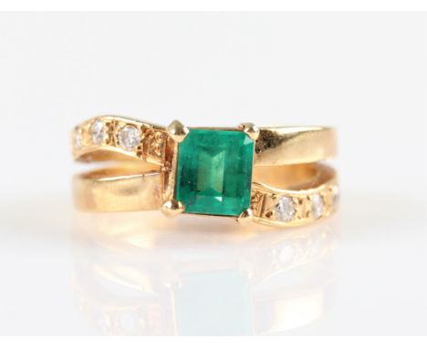An emerald and diamond ring, set with a central emerald cut emerald, origin believed to be Columbian, measuring approx. 5x6mm