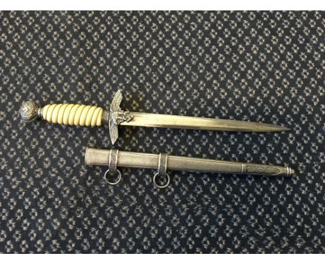 A German style officers dagger with stamp to blade in metal scabbard.