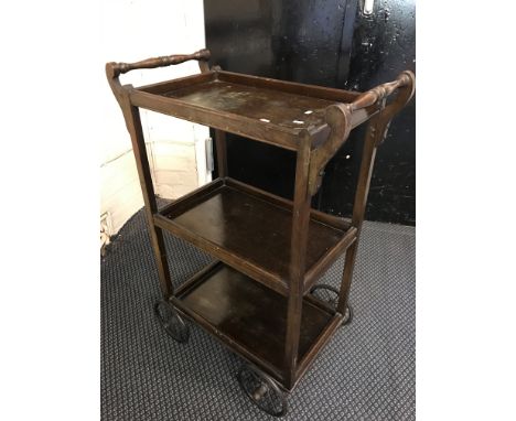A three tier oak high tea serving trolley with metal wire spoked wheels together with a standard lamp.