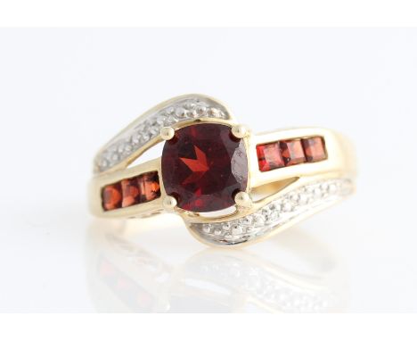 A hallmarked 9ct yellow gold garnet ring, set with central round cut garnet, shoulders set with three square cut garnets flan