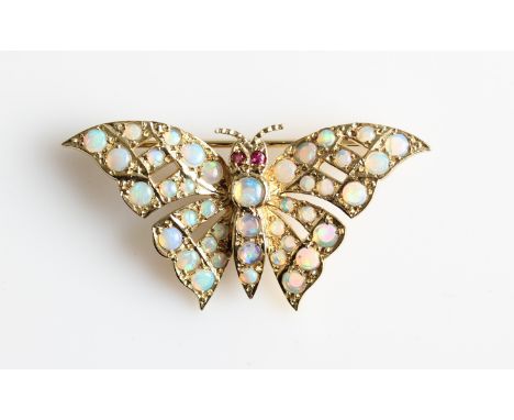 A 9ct yellow gold opal and ruby set butterfly brooch, set with variously sized round opal cabochons to body and round cut rub