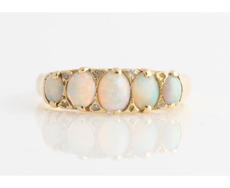 An 18ct yellow gold opal and diamond ring, set with five graduated oval opal cabochons, interspersed with rose cut diamond ac