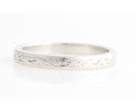 An engraved wedding band, stamped PLAT, ring size K½.