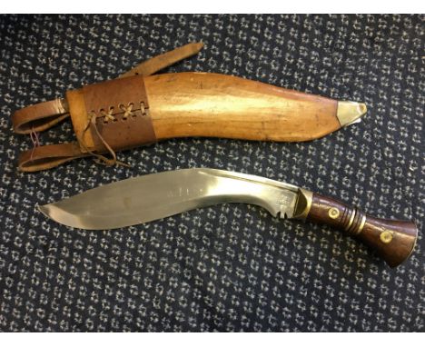 A 1917 Khukuri with stamp to blade, mahogany and brass handle and leather and wood scabbard with brass tip.