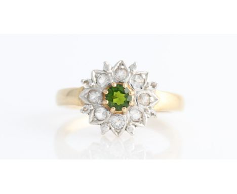 A hallmarked 9ct yellow gold green and colourless stone flower design ring, set with central round cut green stone surrounded