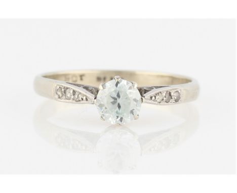 A colourless zircon and diamond ring, set with central round cut colourless zircon, flanked to either side with three rose cu